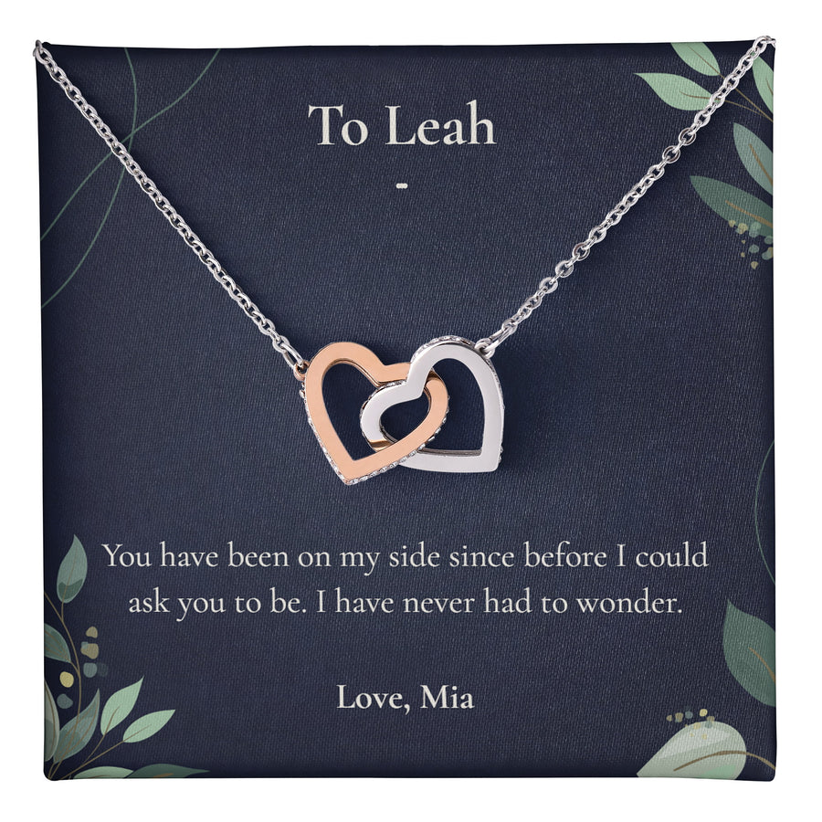 Entangled Hearts Necklace lying on a personalised message card addressed to Leah.